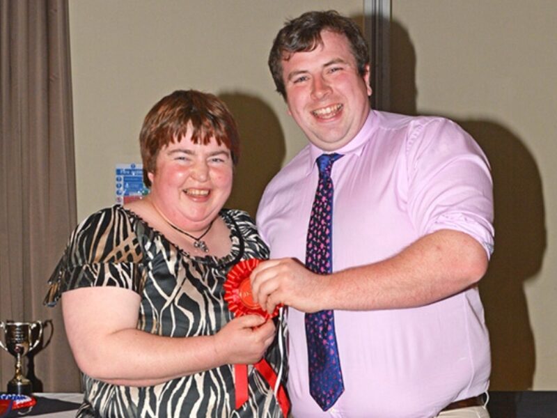 Robert McConnell receiving his prize for holding and restraining a calf section from Wendy Young